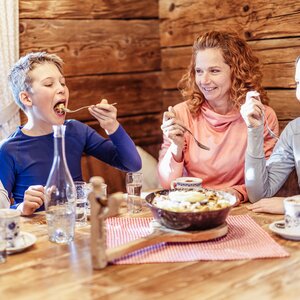 Eine Familie teilt sich gemeinsam eine Pfanne Kaiserschmarrn auf einer Skihütte im Ski Juwel Alpbachtal Wildschönau  | © Ski Juwel Alpbachtal Wildschönau  | shootandstyle 