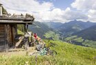 Biken in Alpbach | © Alpbachtal Tourismus | Matthias Sedlak Ein Paar rastet auf einer Bank vor einer Alm und genießt die schöne Aussicht ins Alpbachtal | © Alpbachtal Tourismus | Matthias Sedlak