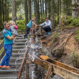 Familie bei den Wasserspielen im Juppi Zauberwald | © Alpbacher Bergbahn | Bildmaße: 6720x4480